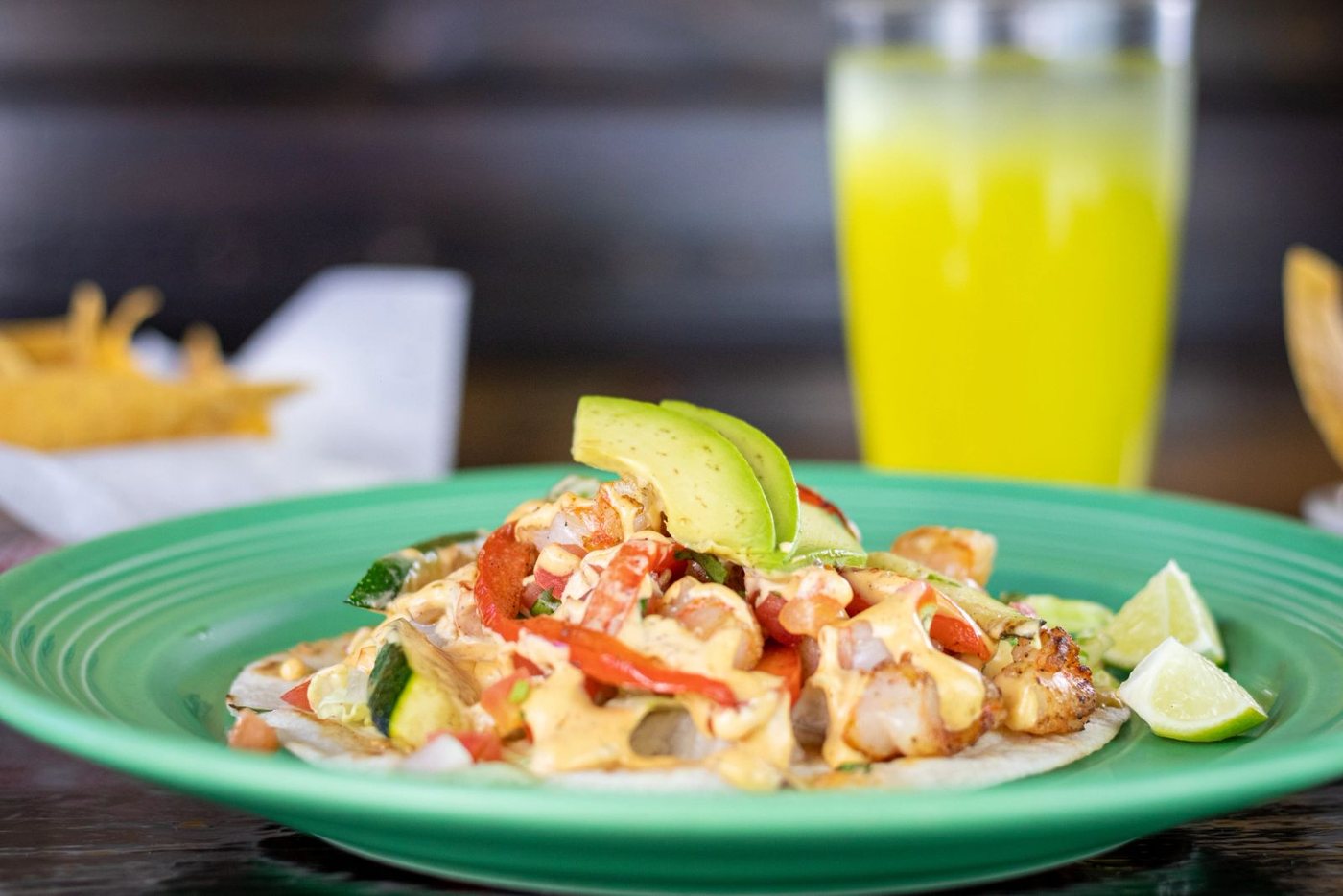 An iGuey plate topped with shrimp, peppers, avocado and lime